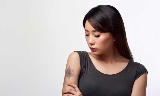 腕のタトゥーを気にする女性